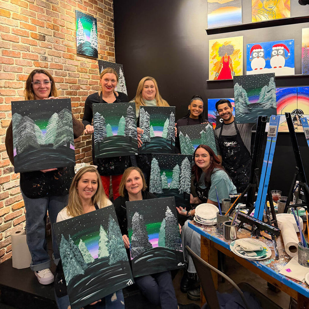 Local Infusion employees showing off their artwork at team building gathering